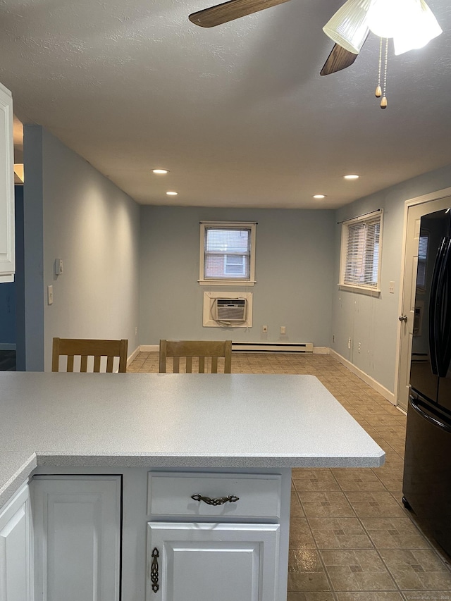 kitchen with ceiling fan, a wall mounted air conditioner, baseboard heating, recessed lighting, and freestanding refrigerator