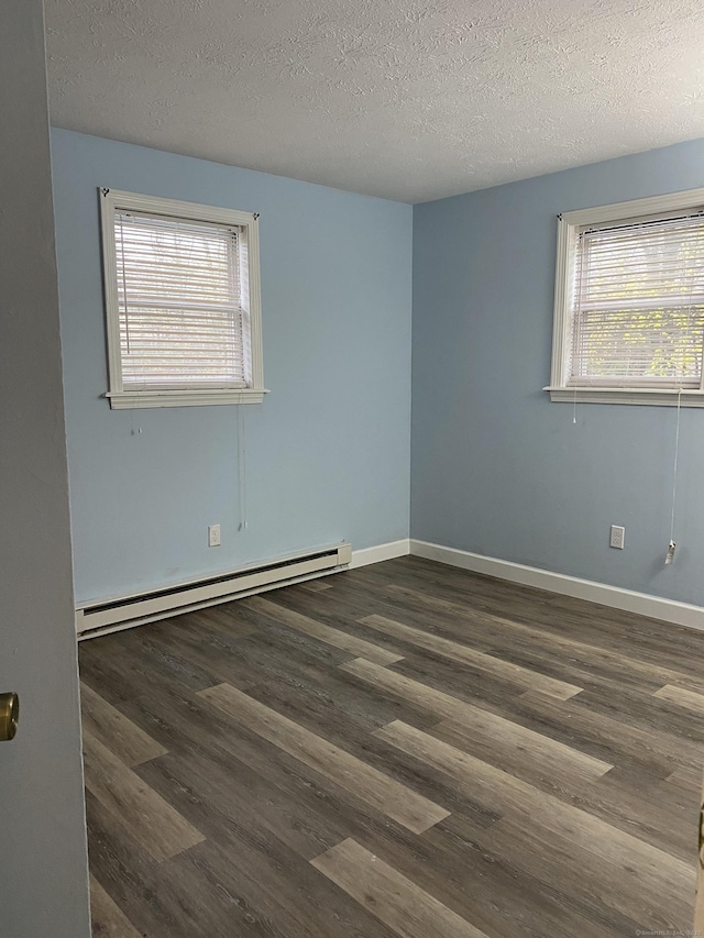 unfurnished room featuring dark wood-style floors, baseboards, and a baseboard radiator