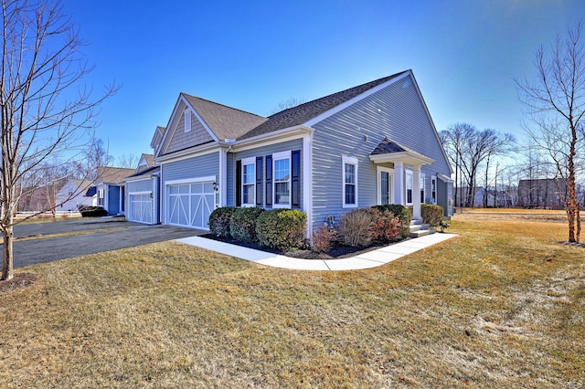 view of home's exterior with a lawn, aphalt driveway, a garage, and roof with shingles