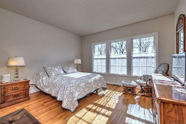 bedroom with baseboards, visible vents, and light wood-style floors