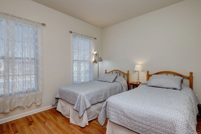 bedroom with baseboards and wood finished floors