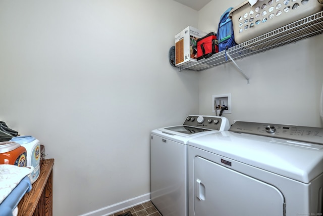 clothes washing area featuring separate washer and dryer, baseboards, and laundry area