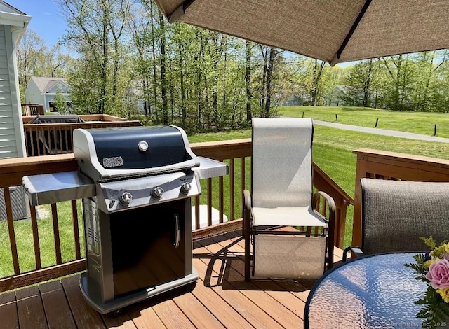 deck with a lawn and area for grilling