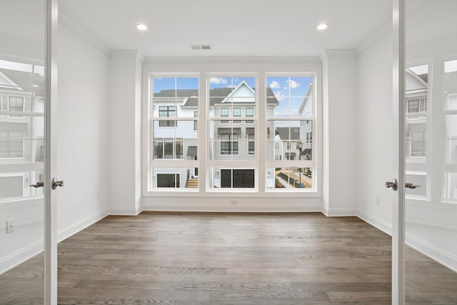 interior space featuring visible vents, wood finished floors, crown molding, and french doors