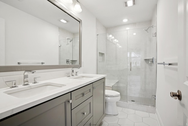 bathroom with visible vents, a sink, a shower stall, and toilet