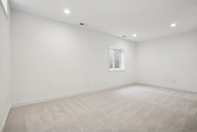 spare room with baseboards, recessed lighting, visible vents, and light colored carpet