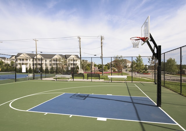 view of sport court featuring a tennis court, community basketball court, and fence