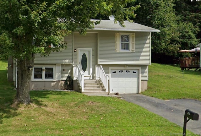 bi-level home featuring driveway, an attached garage, and a front yard