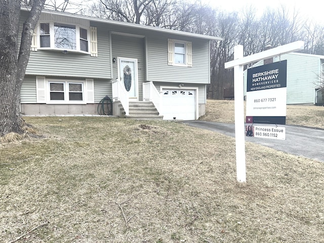 bi-level home featuring a garage and driveway