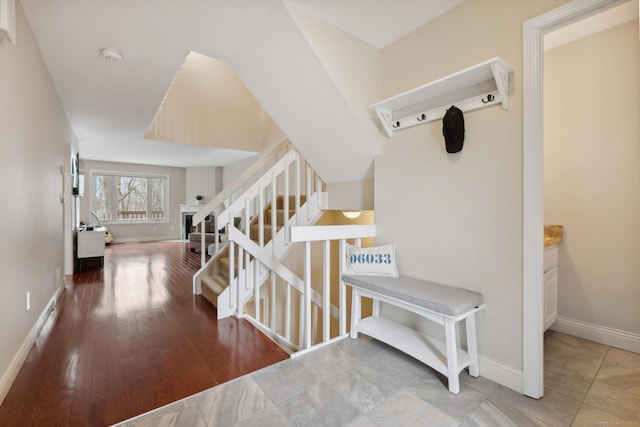 staircase featuring baseboards and wood finished floors