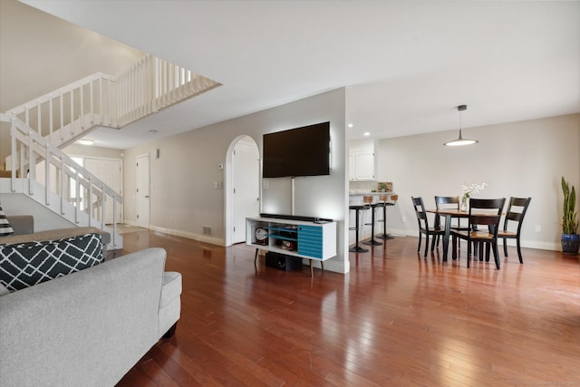 living room with hardwood / wood-style floors, stairs, and baseboards