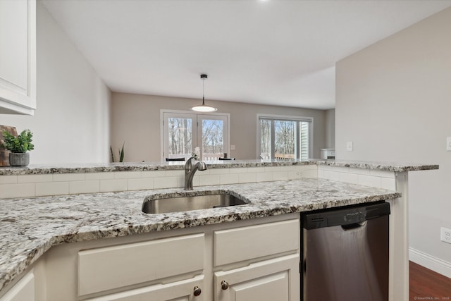 kitchen with a sink, light stone counters, baseboards, dishwasher, and hanging light fixtures