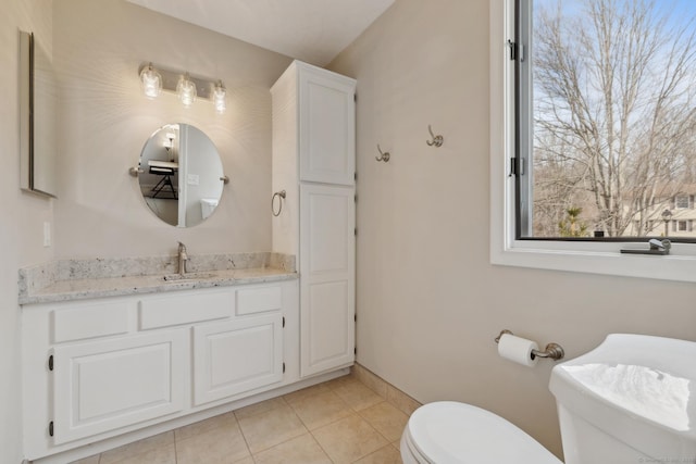 half bathroom featuring tile patterned flooring, toilet, vanity, and baseboards