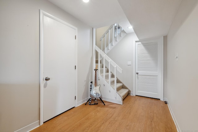 staircase featuring recessed lighting, baseboards, and wood finished floors