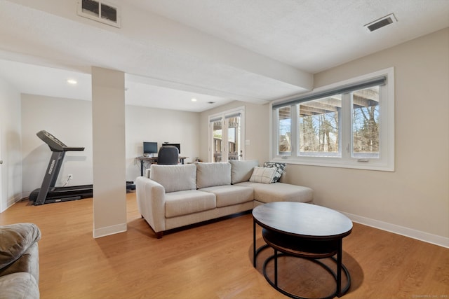 living room featuring recessed lighting, visible vents, light wood-type flooring, and baseboards