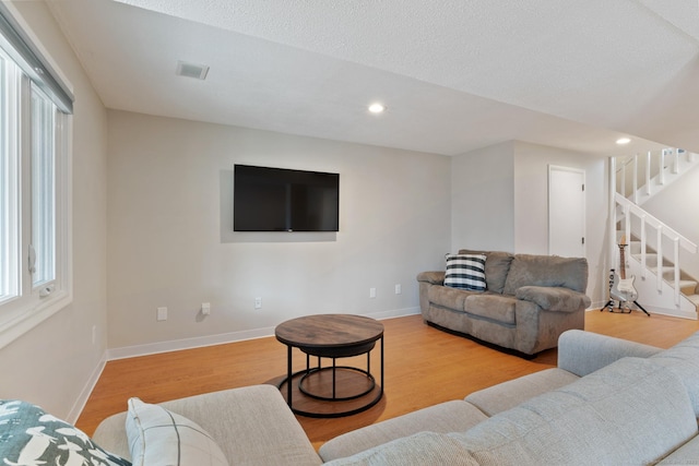 living room with visible vents, wood finished floors, recessed lighting, stairway, and baseboards