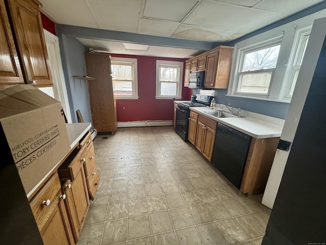 kitchen featuring brown cabinetry, black appliances, light countertops, and a sink