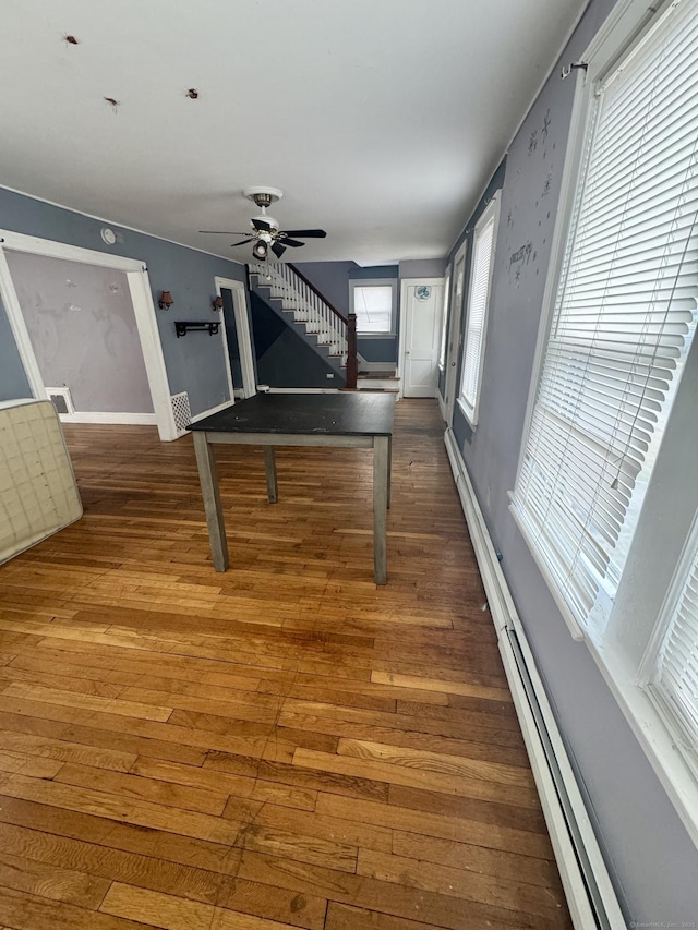 recreation room with ceiling fan, wood finished floors, visible vents, and baseboards