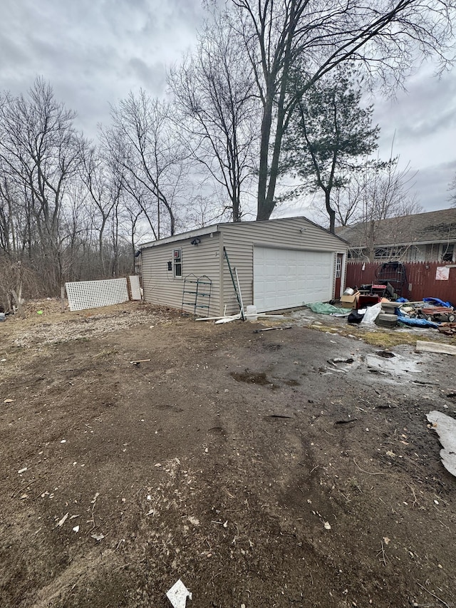 exterior space with an outbuilding, a garage, and fence