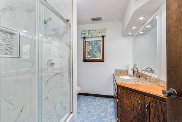 full bath with vanity, visible vents, baseboards, a shower stall, and toilet