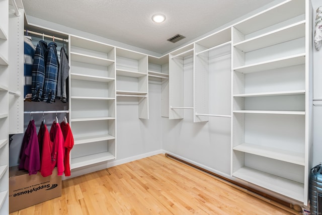 walk in closet featuring visible vents and wood finished floors