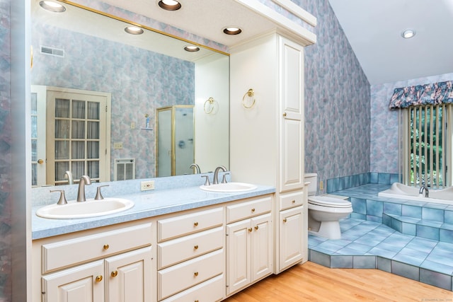 bathroom with visible vents, a shower stall, wallpapered walls, and a sink