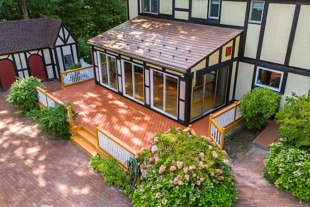 wooden deck with a storage shed and an outdoor structure