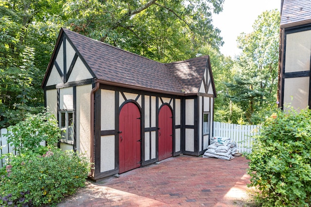 view of outbuilding featuring an outdoor structure and fence