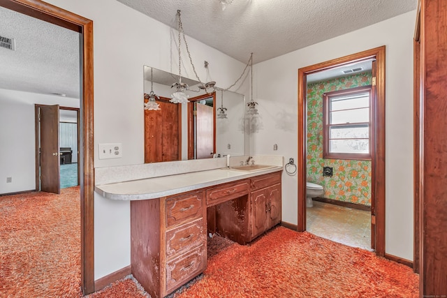 bathroom featuring a textured ceiling, toilet, visible vents, vanity, and baseboards