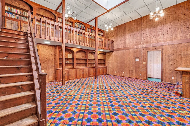 wine room featuring a high ceiling and wood walls