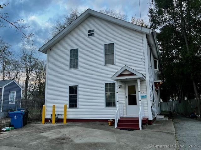 traditional-style house with entry steps and fence