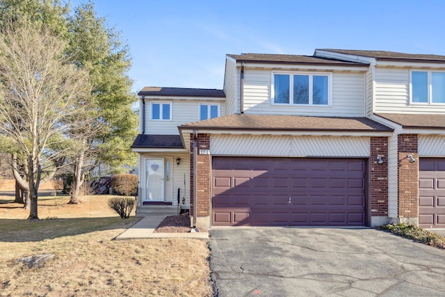 view of front of house featuring aphalt driveway, a garage, and brick siding