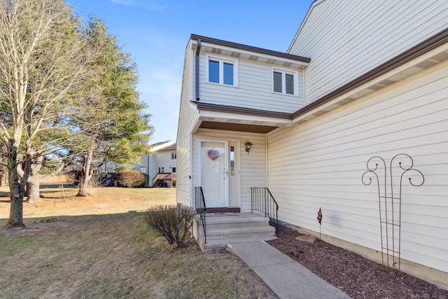 view of exterior entry featuring a yard