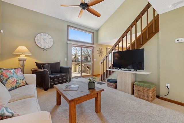 living room featuring baseboards, ceiling fan, stairway, carpet floors, and high vaulted ceiling