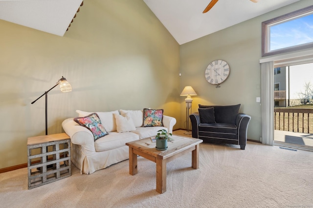 carpeted living room with ceiling fan, baseboards, and high vaulted ceiling