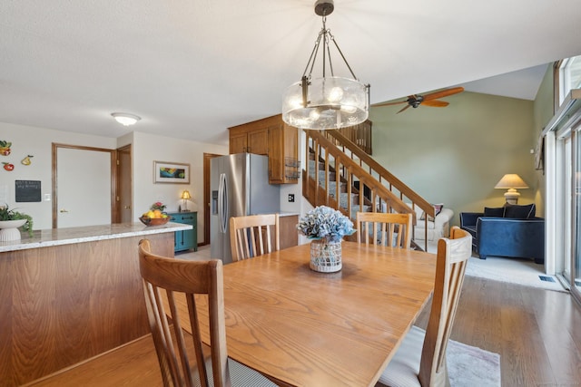 dining area featuring light wood-style flooring and stairs