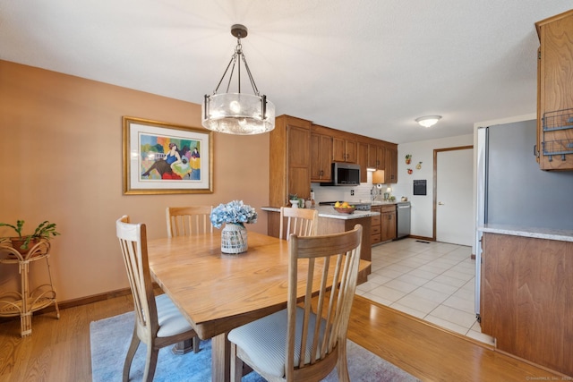 dining room featuring light wood-style flooring and baseboards