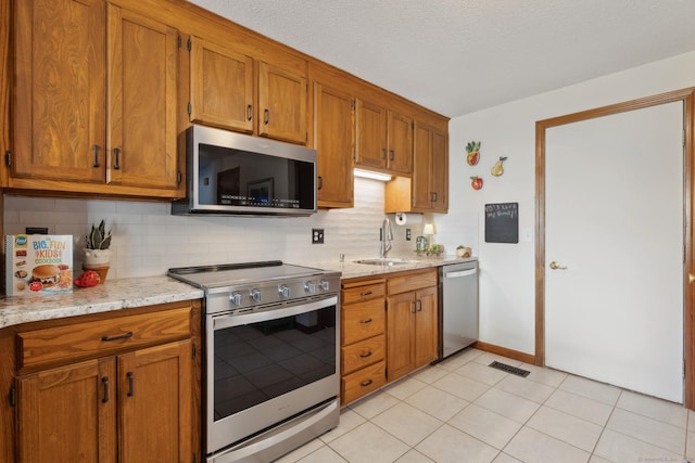 kitchen featuring a sink, brown cabinetry, and stainless steel appliances