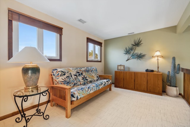 living area featuring a wealth of natural light, visible vents, and baseboards