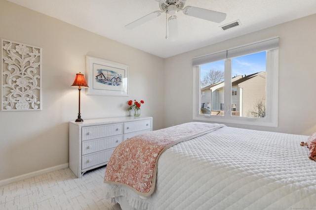 bedroom featuring visible vents, light colored carpet, baseboards, and ceiling fan