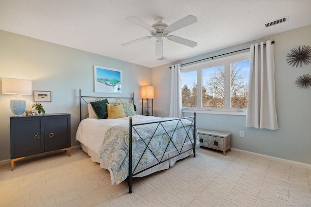 bedroom with baseboards, visible vents, and ceiling fan