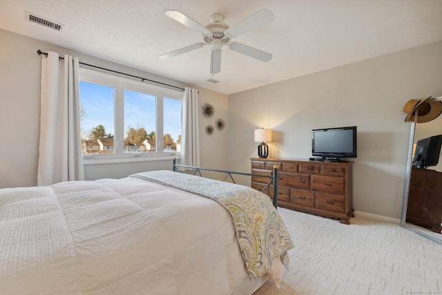 bedroom with ceiling fan, light colored carpet, visible vents, and baseboards