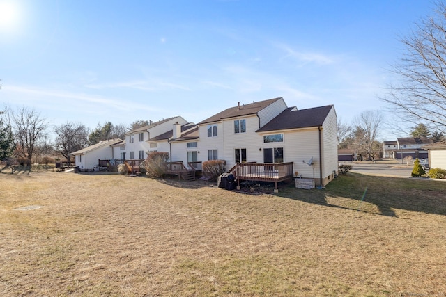 back of house featuring a wooden deck and a yard