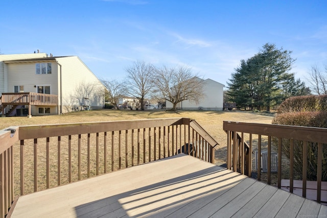 wooden terrace featuring a lawn and stairs