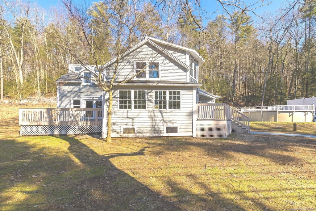 back of property featuring a yard and a wooden deck