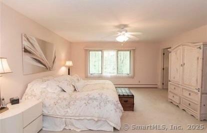 bedroom featuring a baseboard heating unit and light carpet