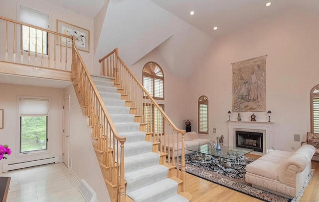 7 Canterbury Ln, Monroe, CT 06468 - living area featuring a baseboard radiator, high vaulted ceiling, stairway, recessed lighting, and a fireplace
