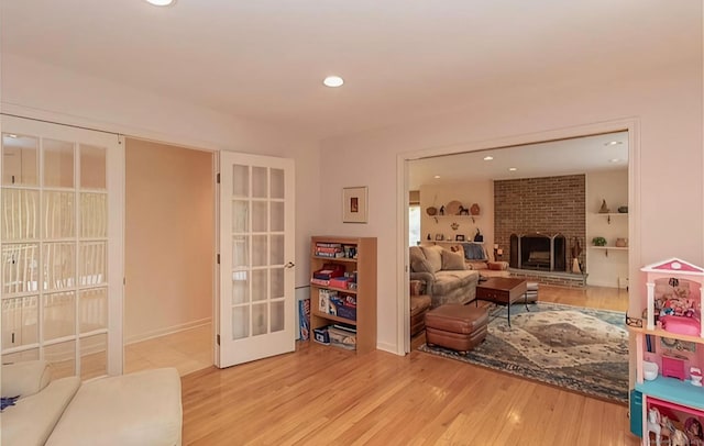 7 Canterbury Ln, Monroe, CT 06468 - living area with wood finished floors, recessed lighting, a brick fireplace, and french doors