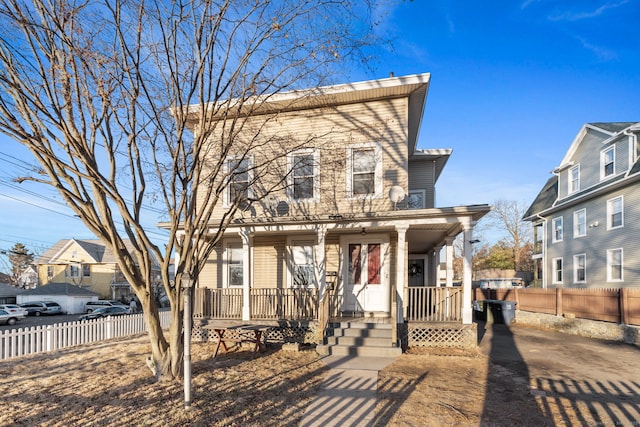 view of front of home with a porch and fence