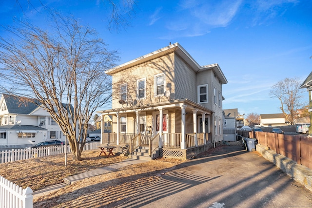 view of front of property with a residential view, fence, and a porch